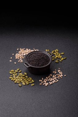 Bir kasede siyah susam tohumu, yağ ve sağlıklı yemek için bir malzeme. Tasarımınız için yiyecek arkaplanı olarak siyah susam