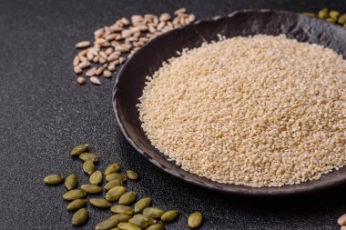 Kasedeki beyaz susam tohumları, yağ ve sağlıklı yemek için bir malzeme. Tasarımınız için yiyecek arka planı olarak beyaz susam