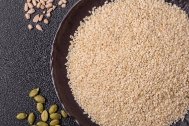 Kasedeki beyaz susam tohumları, yağ ve sağlıklı yemek için bir malzeme. Tasarımınız için yiyecek arka planı olarak beyaz susam