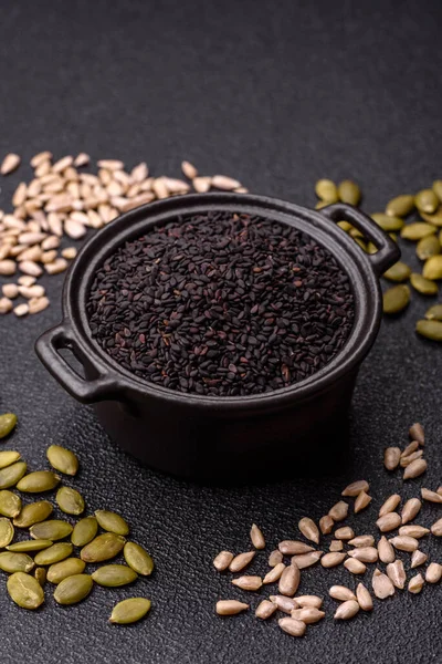 Bir kasede siyah susam tohumu, yağ ve sağlıklı yemek için bir malzeme. Tasarımınız için yiyecek arkaplanı olarak siyah susam