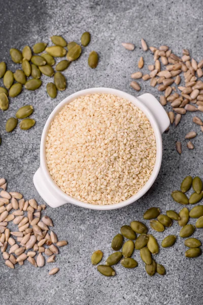 Kasedeki beyaz susam tohumları, yağ ve sağlıklı yemek için bir malzeme. Tasarımınız için yiyecek arka planı olarak beyaz susam