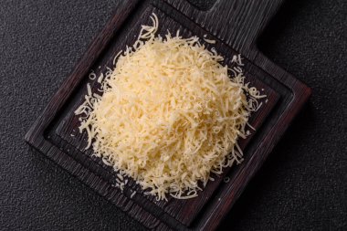 Pişirme veya pişirme malzemesi olarak rendelenmiş parmesan peyniri. Tasarımınız için yemek arkaplanı olarak rendelenmiş parmesan peyniri
