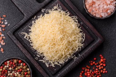 Pişirme veya pişirme malzemesi olarak rendelenmiş parmesan peyniri. Tasarımınız için yemek arkaplanı olarak rendelenmiş parmesan peyniri