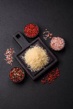 Pişirme veya pişirme malzemesi olarak rendelenmiş parmesan peyniri. Tasarımınız için yemek arkaplanı olarak rendelenmiş parmesan peyniri