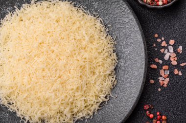 Pişirme veya pişirme malzemesi olarak rendelenmiş parmesan peyniri. Tasarımınız için yemek arkaplanı olarak rendelenmiş parmesan peyniri