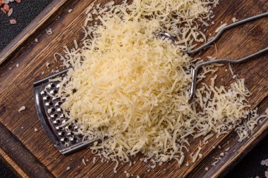 Pişirme veya pişirme malzemesi olarak rendelenmiş parmesan peyniri. Tasarımınız için yemek arkaplanı olarak rendelenmiş parmesan peyniri