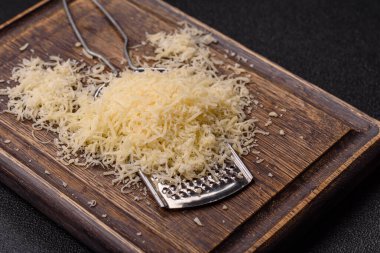 Pişirme veya pişirme malzemesi olarak rendelenmiş parmesan peyniri. Tasarımınız için yemek arkaplanı olarak rendelenmiş parmesan peyniri