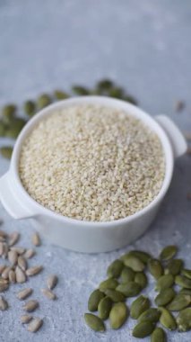 Kasedeki beyaz susam tohumları, yağ ve sağlıklı yemek için bir malzeme. Tasarımınız için yiyecek arka planı olarak beyaz susam