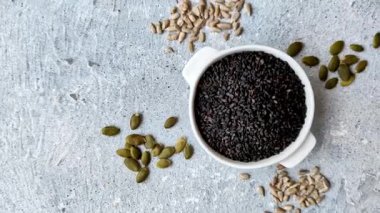 Bir kasede siyah susam tohumu, yağ ve sağlıklı yemek için bir malzeme. Tasarımınız için yiyecek arkaplanı olarak siyah susam