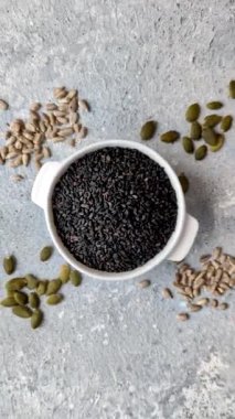 Bir kasede siyah susam tohumu, yağ ve sağlıklı yemek için bir malzeme. Tasarımınız için yiyecek arkaplanı olarak siyah susam