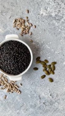 Bir kasede siyah susam tohumu, yağ ve sağlıklı yemek için bir malzeme. Tasarımınız için yiyecek arkaplanı olarak siyah susam