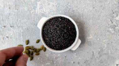 Bir kasede siyah susam tohumu, yağ ve sağlıklı yemek için bir malzeme. Tasarımınız için yiyecek arkaplanı olarak siyah susam