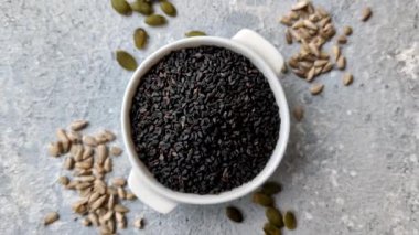 Bir kasede siyah susam tohumu, yağ ve sağlıklı yemek için bir malzeme. Tasarımınız için yiyecek arkaplanı olarak siyah susam