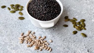 Bir kasede siyah susam tohumu, yağ ve sağlıklı yemek için bir malzeme. Tasarımınız için yiyecek arkaplanı olarak siyah susam