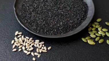 Bir kasede siyah susam tohumu, yağ ve sağlıklı yemek için bir malzeme. Tasarımınız için yiyecek arkaplanı olarak siyah susam