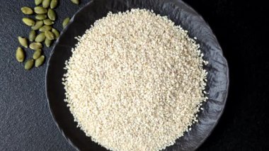 Kasedeki beyaz susam tohumları, yağ ve sağlıklı yemek için bir malzeme. Tasarımınız için yiyecek arka planı olarak beyaz susam