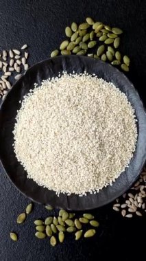 Kasedeki beyaz susam tohumları, yağ ve sağlıklı yemek için bir malzeme. Tasarımınız için yiyecek arka planı olarak beyaz susam