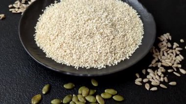 Kasedeki beyaz susam tohumları, yağ ve sağlıklı yemek için bir malzeme. Tasarımınız için yiyecek arka planı olarak beyaz susam