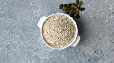 Kasedeki beyaz susam tohumları, yağ ve sağlıklı yemek için bir malzeme. Tasarımınız için yiyecek arka planı olarak beyaz susam