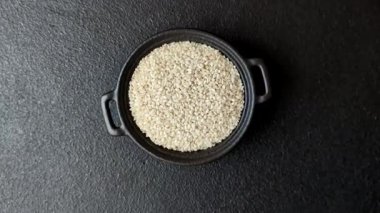 Kasedeki beyaz susam tohumları, yağ ve sağlıklı yemek için bir malzeme. Tasarımınız için yiyecek arka planı olarak beyaz susam