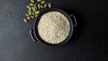 Kasedeki beyaz susam tohumları, yağ ve sağlıklı yemek için bir malzeme. Tasarımınız için yiyecek arka planı olarak beyaz susam