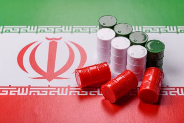 İran bayrağında bulunan petrol, gaz ve kimyasalların metal varilleri. Tasarımınızın arka planı olarak İran petrolü varilleri