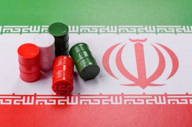 İran bayrağında bulunan petrol, gaz ve kimyasalların metal varilleri. Tasarımınızın arka planı olarak İran petrolü varilleri