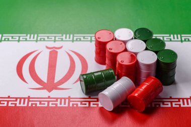 İran bayrağında bulunan petrol, gaz ve kimyasalların metal varilleri. Tasarımınızın arka planı olarak İran petrolü varilleri