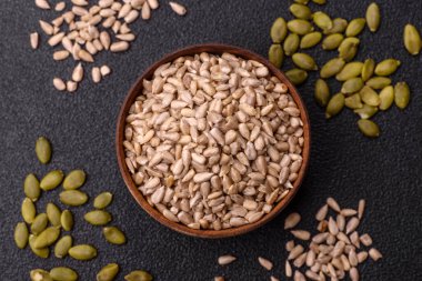 Kabuklu ay çekirdeği çekirdekleri, tuzlanmış, kavrulmuş ya da çiğ, sağlıklı bir bileşendir. Tasarımınız için gıda arka planı olarak ayçiçeği tohumları