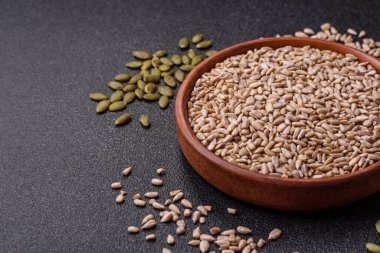 Kabuklu ay çekirdeği çekirdekleri, tuzlanmış, kavrulmuş ya da çiğ, sağlıklı bir bileşendir. Tasarımınız için gıda arka planı olarak ayçiçeği tohumları