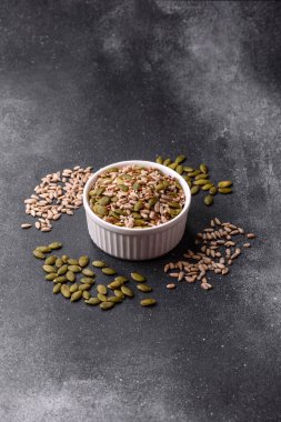 Sağlıklı yiyecekler için kabuklu ayçiçeği, susam, balkabağı ve keten tohumu çekirdekleri. Tasarımınız için gıda arka planı olarak tohumlar ve tahıllar.