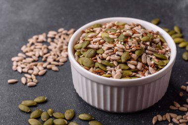 Sağlıklı yiyecekler için kabuklu ayçiçeği, susam, balkabağı ve keten tohumu çekirdekleri. Tasarımınız için gıda arka planı olarak tohumlar ve tahıllar.