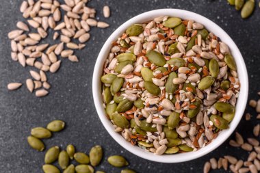 Sağlıklı yiyecekler için kabuklu ayçiçeği, susam, balkabağı ve keten tohumu çekirdekleri. Tasarımınız için gıda arka planı olarak tohumlar ve tahıllar.