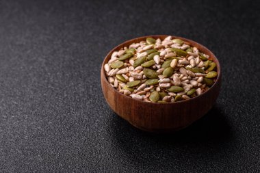 Sağlıklı yiyecekler için kabuklu ayçiçeği, susam, balkabağı ve keten tohumu çekirdekleri. Tasarımınız için gıda arka planı olarak tohumlar ve tahıllar.