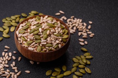 Sağlıklı yiyecekler için kabuklu ayçiçeği, susam, balkabağı ve keten tohumu çekirdekleri. Tasarımınız için gıda arka planı olarak tohumlar ve tahıllar.