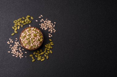 Sağlıklı yiyecekler için kabuklu ayçiçeği, susam, balkabağı ve keten tohumu çekirdekleri. Tasarımınız için gıda arka planı olarak tohumlar ve tahıllar.