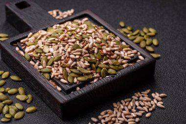 Sağlıklı yiyecekler için kabuklu ayçiçeği, susam, balkabağı ve keten tohumu çekirdekleri. Tasarımınız için gıda arka planı olarak tohumlar ve tahıllar.