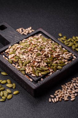 Sağlıklı yiyecekler için kabuklu ayçiçeği, susam, balkabağı ve keten tohumu çekirdekleri. Tasarımınız için gıda arka planı olarak tohumlar ve tahıllar.