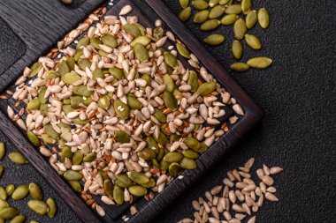 Sağlıklı yiyecekler için kabuklu ayçiçeği, susam, balkabağı ve keten tohumu çekirdekleri. Tasarımınız için gıda arka planı olarak tohumlar ve tahıllar.