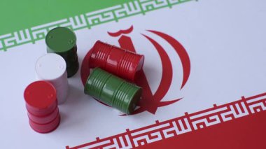 İran bayrağında bulunan petrol, gaz ve kimyasalların metal varilleri. Tasarımınızın arka planı olarak İran petrolü varilleri