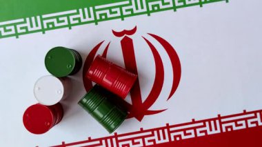 İran bayrağında bulunan petrol, gaz ve kimyasalların metal varilleri. Tasarımınızın arka planı olarak İran petrolü varilleri