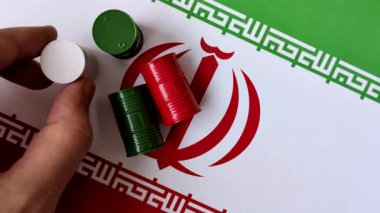 İran bayrağında bulunan petrol, gaz ve kimyasalların metal varilleri. Tasarımınızın arka planı olarak İran petrolü varilleri
