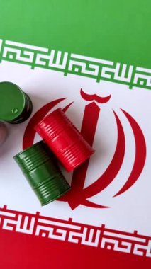 İran bayrağında bulunan petrol, gaz ve kimyasalların metal varilleri. Tasarımınızın arka planı olarak İran petrolü varilleri