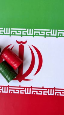 İran bayrağında bulunan petrol, gaz ve kimyasalların metal varilleri. Tasarımınızın arka planı olarak İran petrolü varilleri