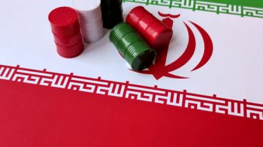 İran bayrağında bulunan petrol, gaz ve kimyasalların metal varilleri. Tasarımınızın arka planı olarak İran petrolü varilleri