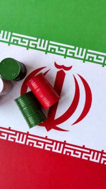 İran bayrağında bulunan petrol, gaz ve kimyasalların metal varilleri. Tasarımınızın arka planı olarak İran petrolü varilleri