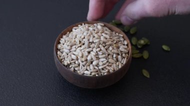 Kabuklu ay çekirdeği çekirdekleri, tuzlanmış, kavrulmuş ya da çiğ, sağlıklı bir bileşendir. Tasarımınız için gıda arka planı olarak ayçiçeği tohumları