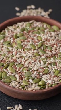 Sağlıklı yiyecekler için kabuklu ayçiçeği, susam, balkabağı ve keten tohumu çekirdekleri. Tasarımınız için gıda arka planı olarak tohumlar ve tahıllar.