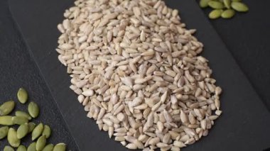 Kabuklu ay çekirdeği çekirdekleri, tuzlanmış, kavrulmuş ya da çiğ, sağlıklı bir bileşendir. Tasarımınız için gıda arka planı olarak ayçiçeği tohumları