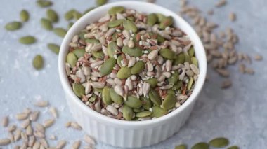 Sağlıklı yiyecekler için kabuklu ayçiçeği, susam, balkabağı ve keten tohumu çekirdekleri. Tasarımınız için gıda arka planı olarak tohumlar ve tahıllar.